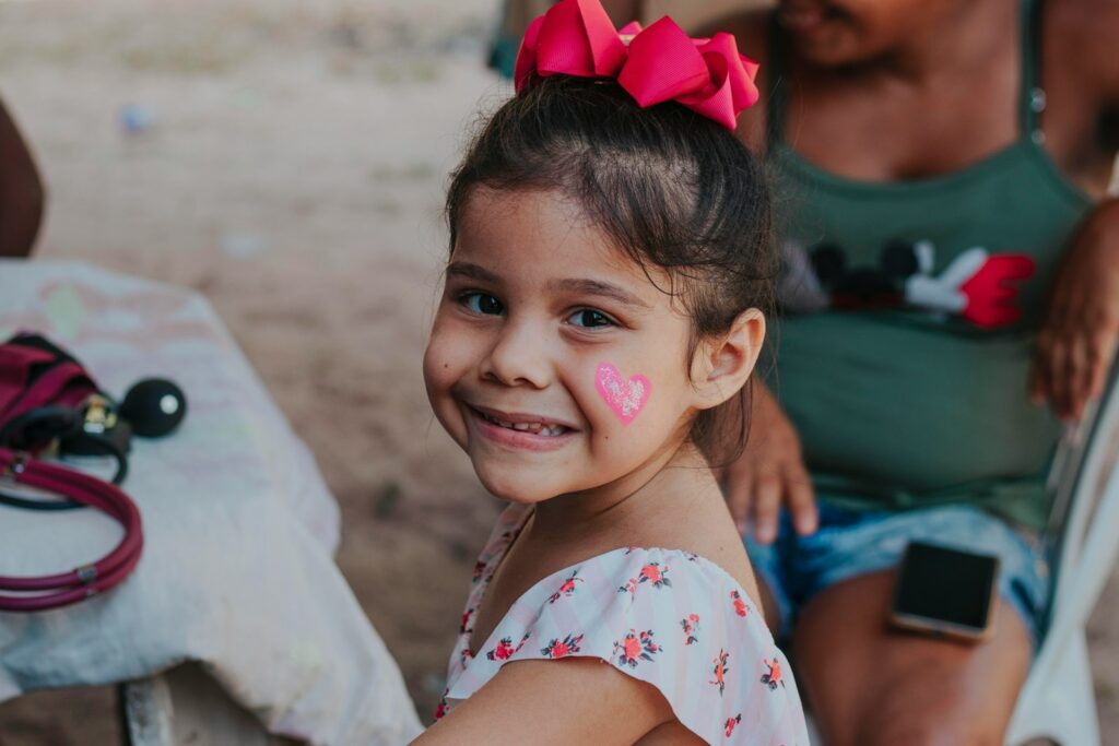 a little girl with a heart painted on her cheek