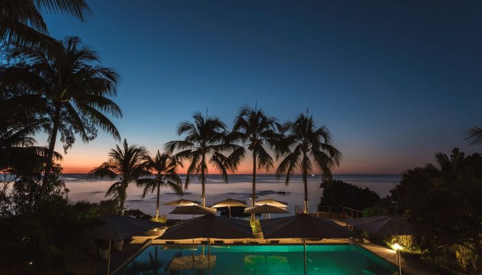 pool surrounded with trees and gazebos
