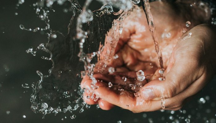 a person holding their hands under a stream of water