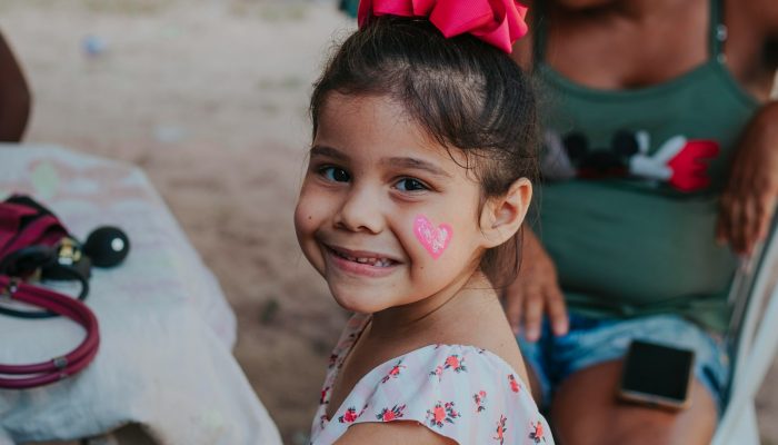 a little girl with a heart painted on her cheek